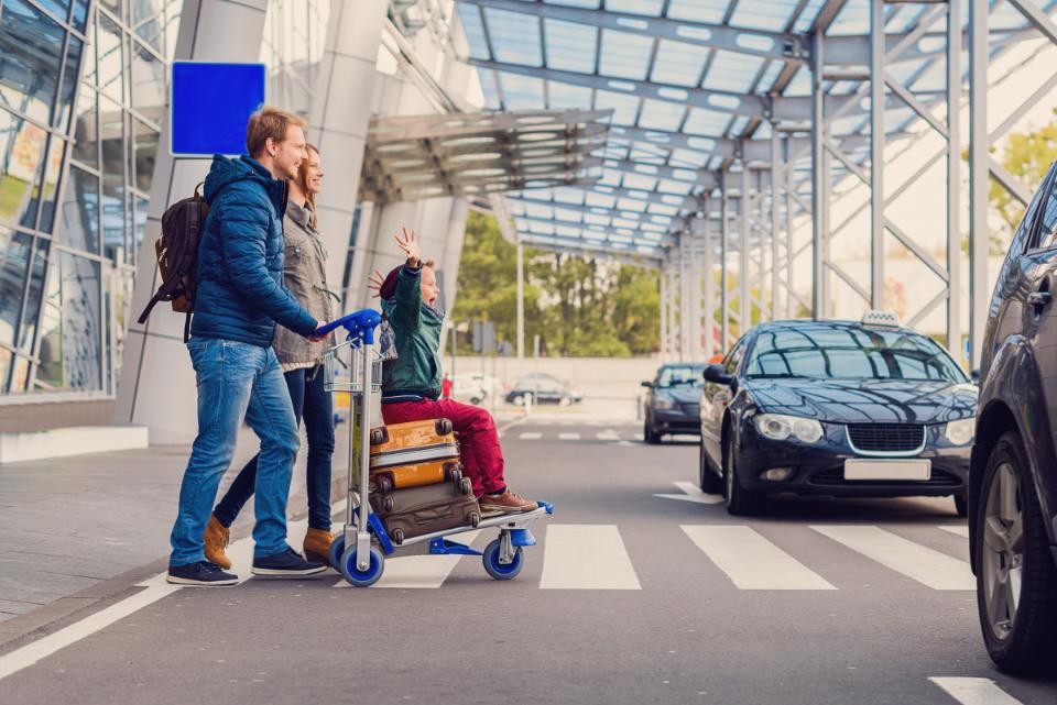 Family walking out of the airport looking for a taxi